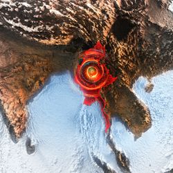 Aerial view of a digitally enhanced map of Southeast Asia showing red concentric circles radiating from Myanmar, indicating seismic activity. Surrounding areas appear topographically detailed.
